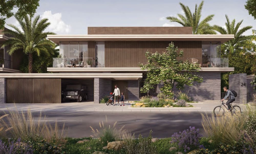 Two-storey villa street front with a slatted garage, a family by the door and a cyclist on the road at Diagon, Athlon in Dubailand.